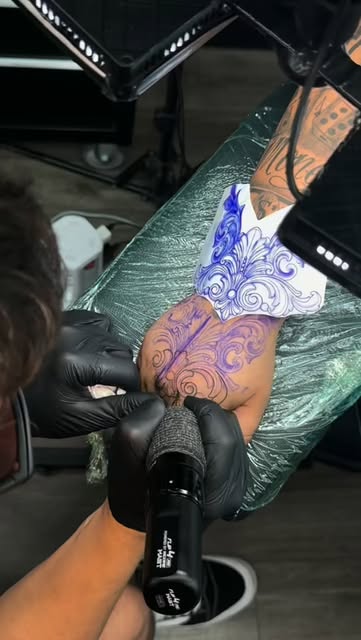 Ornamental hand tattoo in progress, stencil and first lines